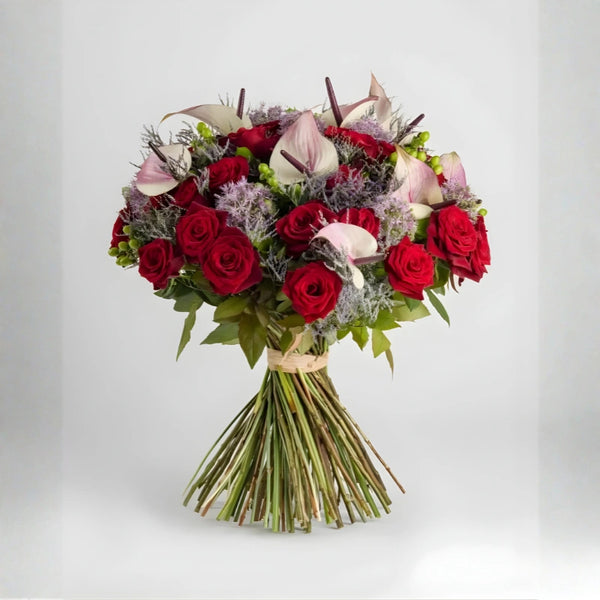 Bouquet of red roses and calla lilies on a light gray background